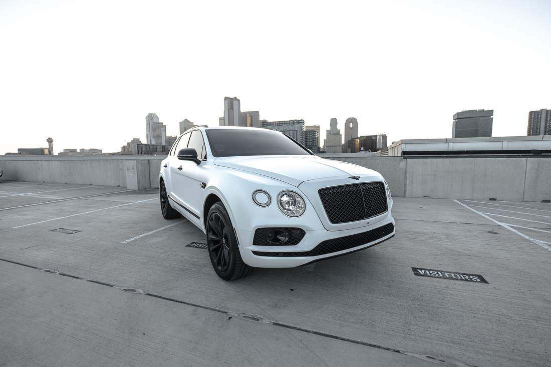 White Bentley Bentayga with the Dallas skyline
